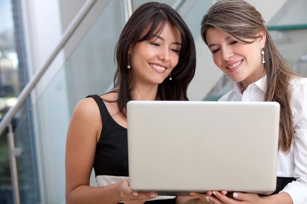 two-latino-business-women-with-laptop-outside two-latino-business-women-with-laptop-outside