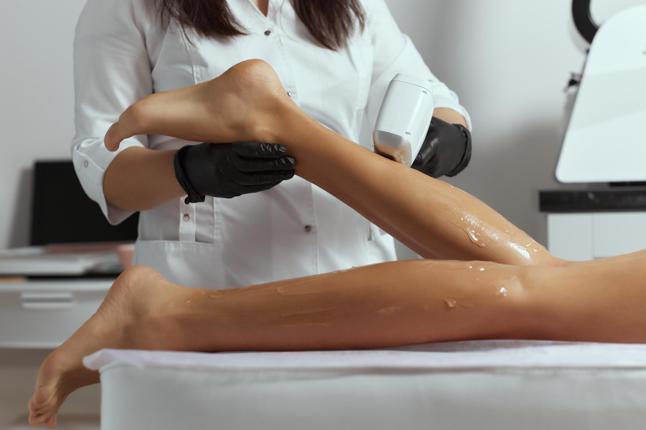 Young African woman getting laser hair removal on her thighs. Young African woman getting laser hair removal on her thighs